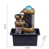 A tabletop water fountain featuring stacked ceramic bowls and a blue glass orb, set in a black rectangular base.