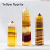 Three yellow fluorite crystal points of varying sizes and colors displayed on a white surface.