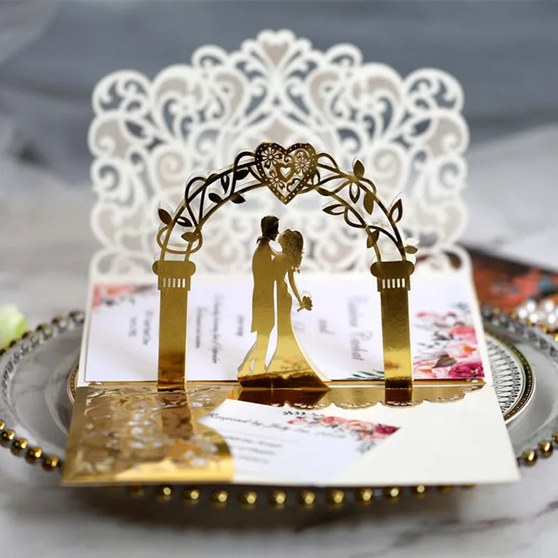 Gold pearl laser cut wedding invitations featuring a gold arch and white lace backdrop