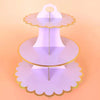 A three-tier cardboard cupcake stand with gold accents, displayed against a light orange background.