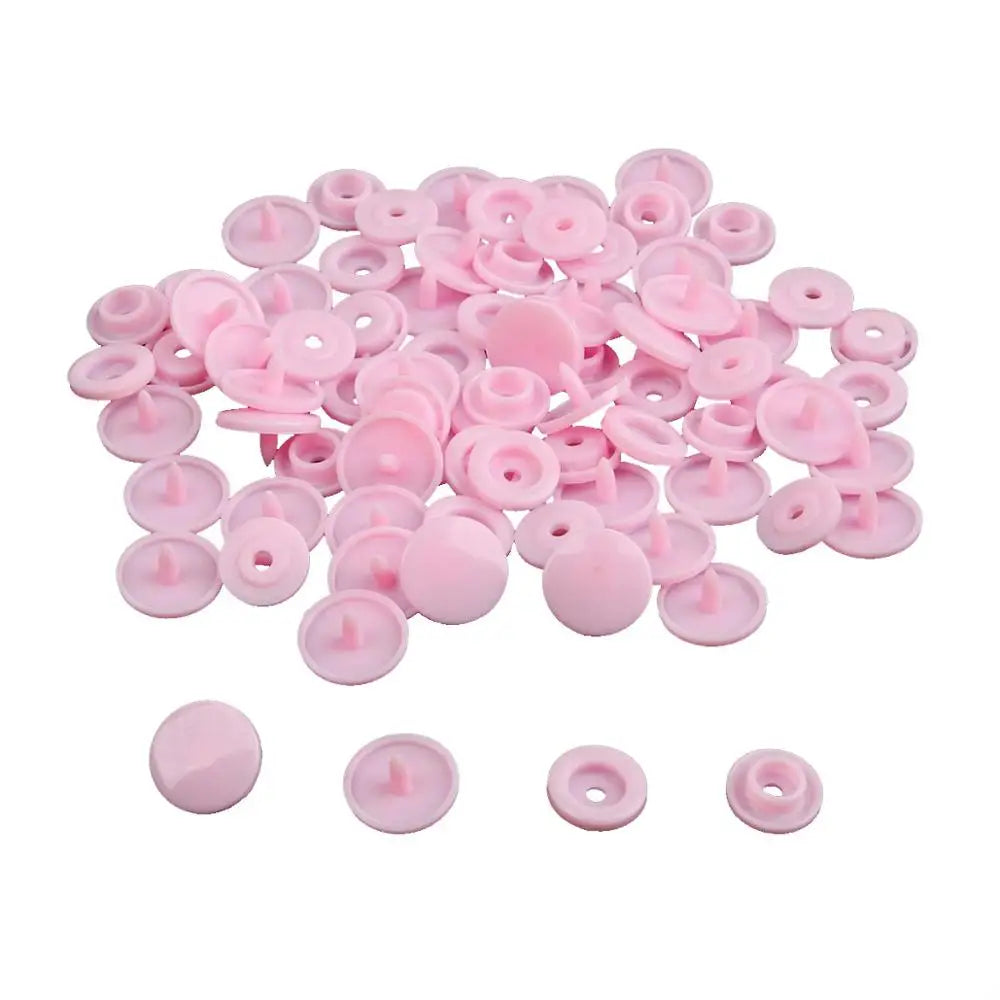A pile of assorted pink snap buttons, measuring 12mm and 10.5mm, for crafting.