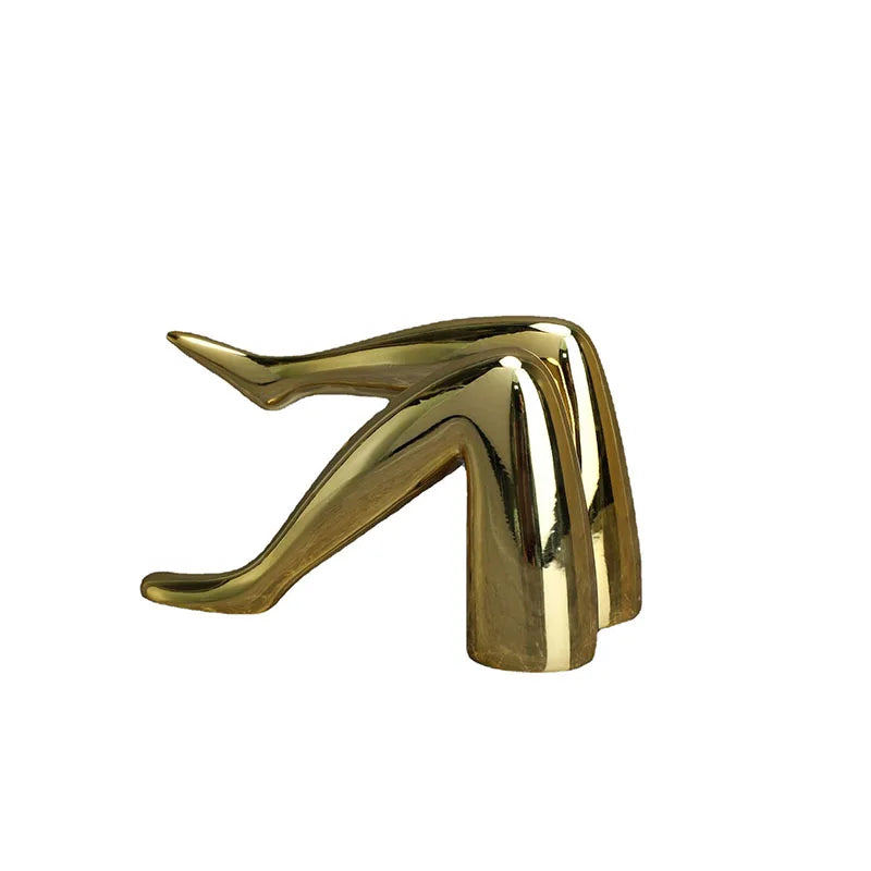 A shiny gold faux finish sculpture of a human body part, possibly a hand or foot.