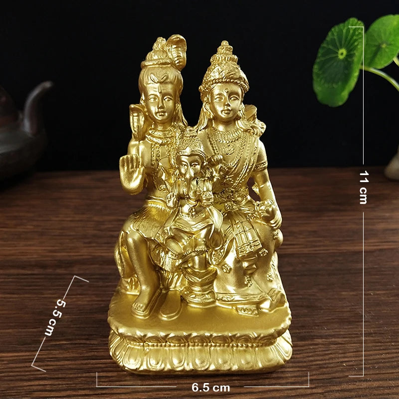 Gold-colored resin figurine of a Hindu or Buddhist deity with a child, displayed on a wooden surface.