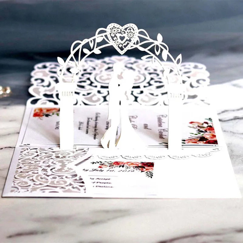 Silver laser cut wedding invitations featuring a heart-shaped floral arch and elegant typography