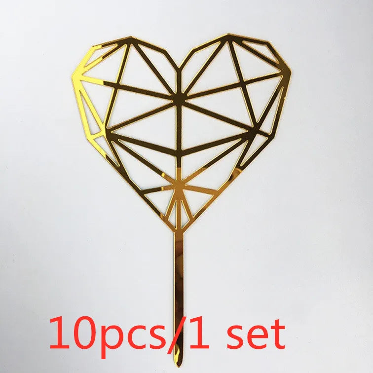 A gold acrylic heart-shaped cake topper with a geometric design on a stick.