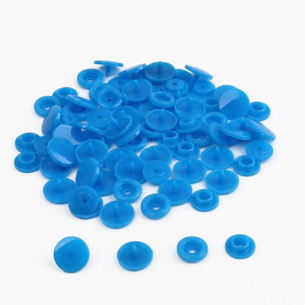 A pile of assorted blue snap buttons, measuring 12mm and 10.5mm, for crafting.
