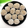 A pile of natural desert rose selenite stones in a black bowl.