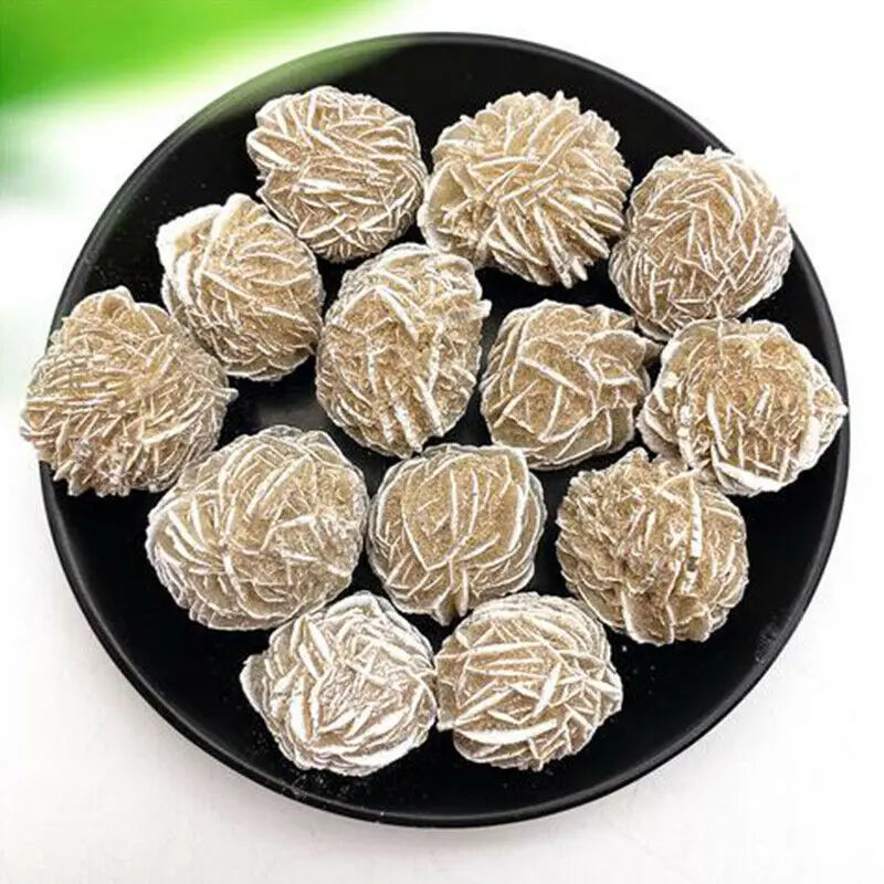 A pile of natural desert rose selenite stones in a black bowl.