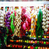 A display of lifelike artificial fruits and vegetables in various colors and shapes for decoration.