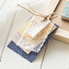 A stack of decorative memo pads and cards in various pastel colors tied with twine on a wooden surface.