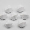 A collection of white acrylic crystal decorations shaped like pyramids or facets.