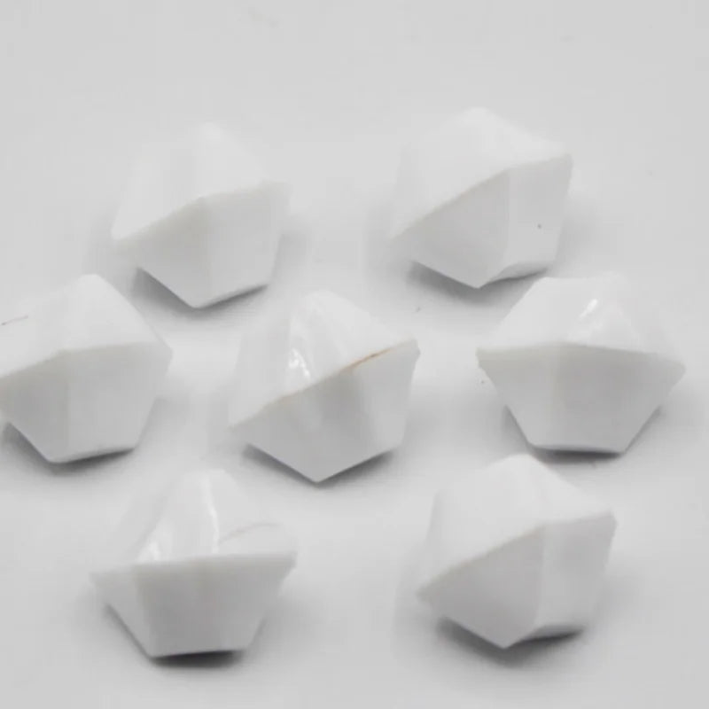 A collection of white acrylic crystal decorations shaped like pyramids or facets.