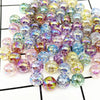 A collection of iridescent round acrylic beads in various shades of purple, green, and blue for jewelry making