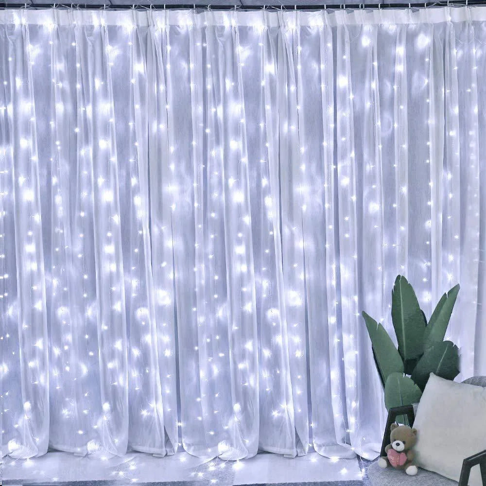 White sheer curtain illuminated by warm white LED string lights for Christmas décor