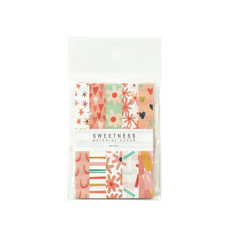 A clear plastic package containing a pack of decorative memo pads and cards with floral patterns in pink, green, and orange t