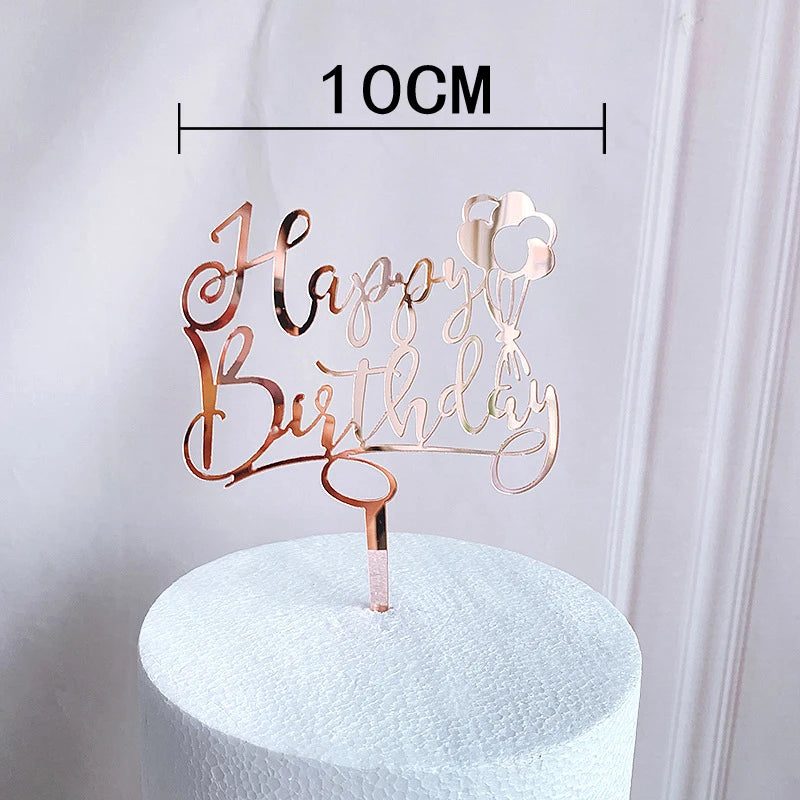Rose gold acrylic happy birthday cake topper with a 1 OCM measurement displayed on a white pedestal.