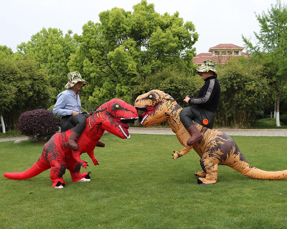 Two people in inflatable T-Rex costumes posing outdoors in a grassy park.