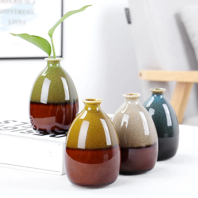 Handgemachte Keramikblumenvase mit grüner Pflanze auf weißem Untergrund