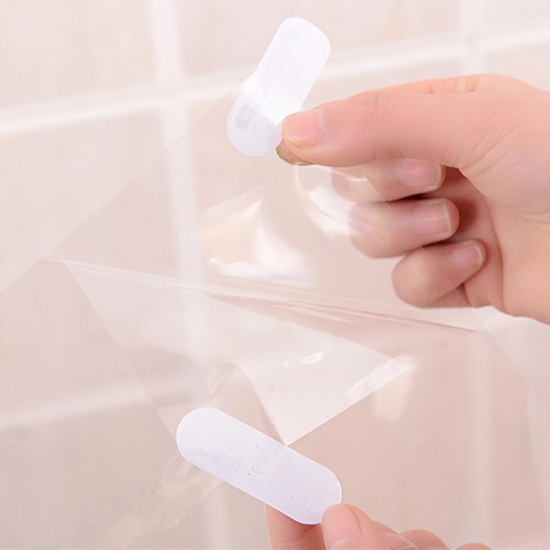 A hand is applying a white, self-adhesive film sticker to a translucent plastic sheet.