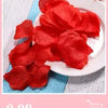 A pile of vibrant red silk rose petals on a white plate.