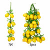 A sprig of artificial yellow citrus fruits and green leaves used for decoration or photography.