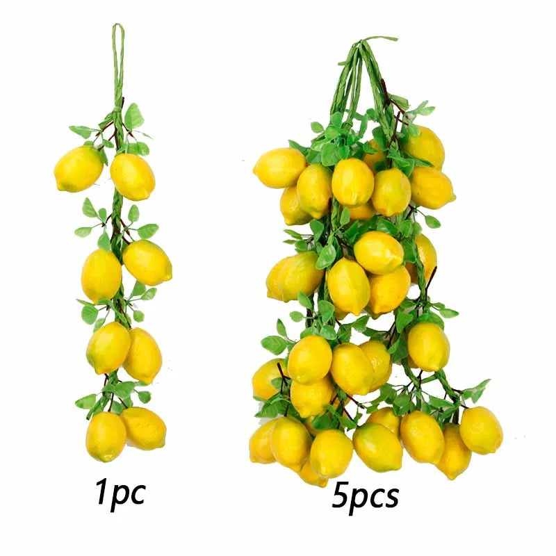 A sprig of artificial yellow citrus fruits and green leaves used for decoration or photography.