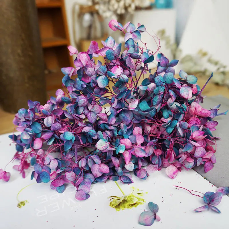 A cluster of handmade dried hydrangea flowers in shades of purple and blue