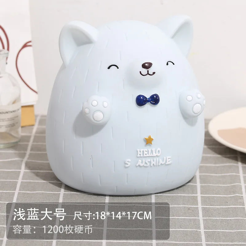 A white cartoon bear-shaped piggy bank with black eyes and a blue bow, sitting on a gray checkered surface.