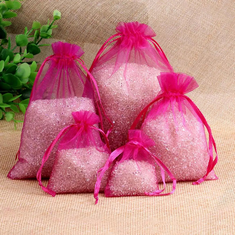 Pink glittery granular material packaged in sheer pink organza drawstring gift pouches