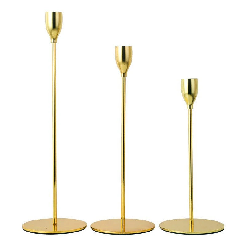 A set of three gold-toned European style iron candle holders with slender stems and round bases.