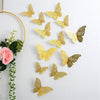 Set aus drei 3D-leeren Schmetterlings-Wandaufklebern in Gold und Bronze, aufgehängt an einem Golddraht.