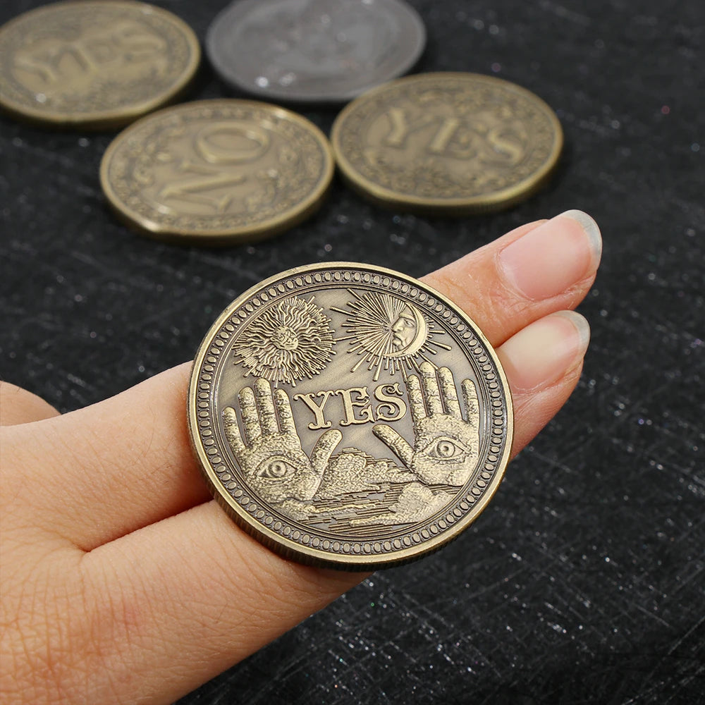 Una mano sostiene una moneda metálica de oro con diseño de puño levantado, con otras monedas dispersas al fondo.