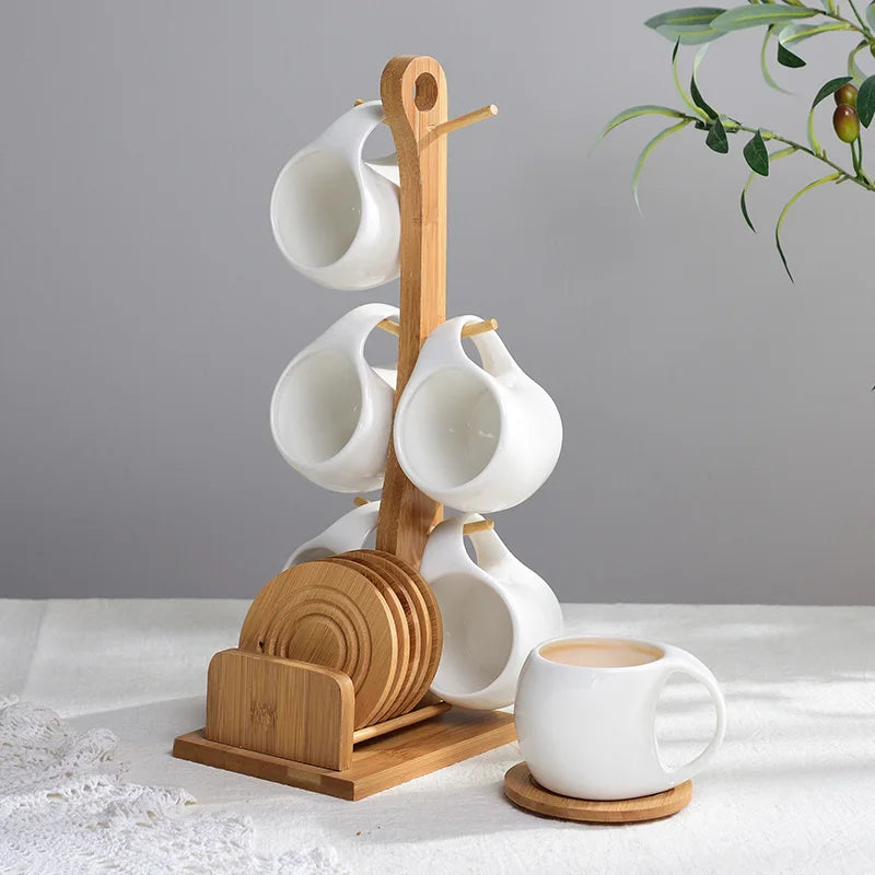 A ceramic coffee mug set is displayed on a bamboo wood stand against a gray background.