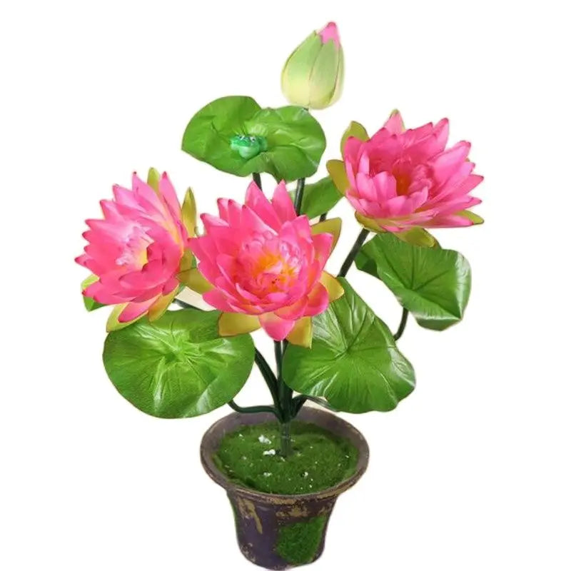 Artificial lotus flower bunch with pink and green accents growing in a pot