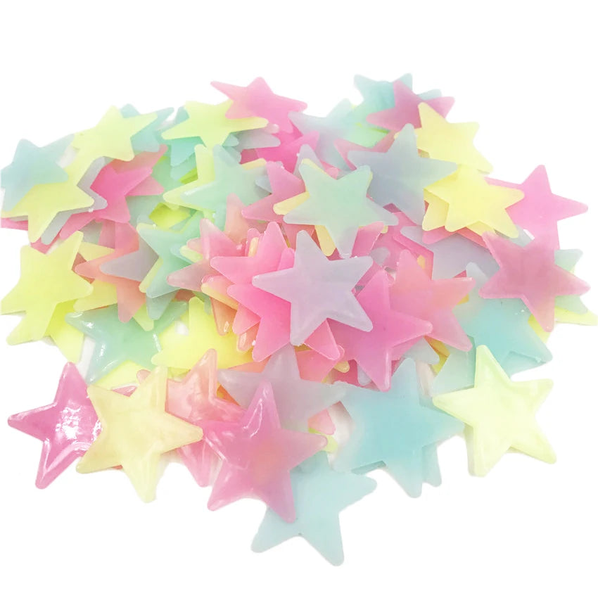 A pile of glow-in-the-dark star and moon wall stickers in various pastel colors like pink, yellow, and blue.