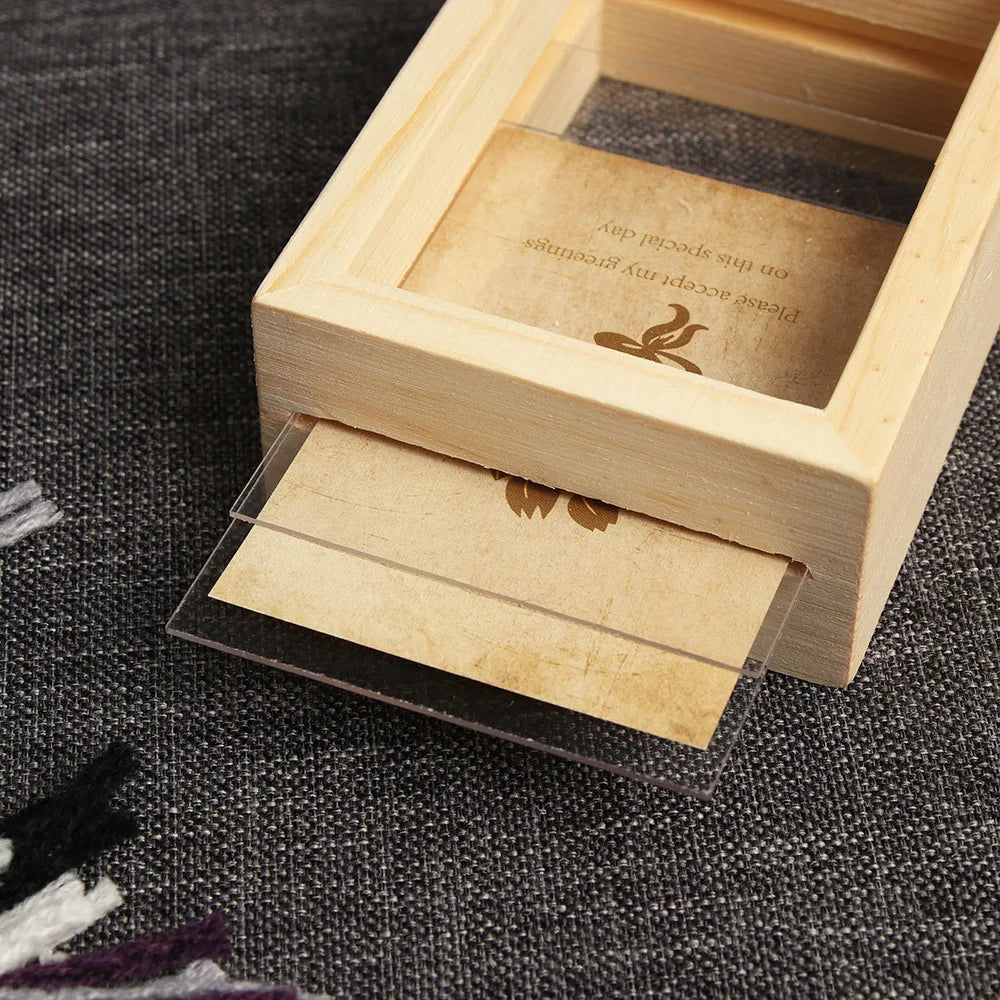 A vintage wooden photo frame set with a clear cover displaying a small aged card.