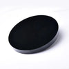 A round, matte black obsidian mirror used for psychic protection and divination.