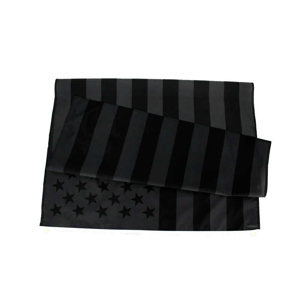 A stack of black and gray American flag banners made of durable polyester for outdoor display.