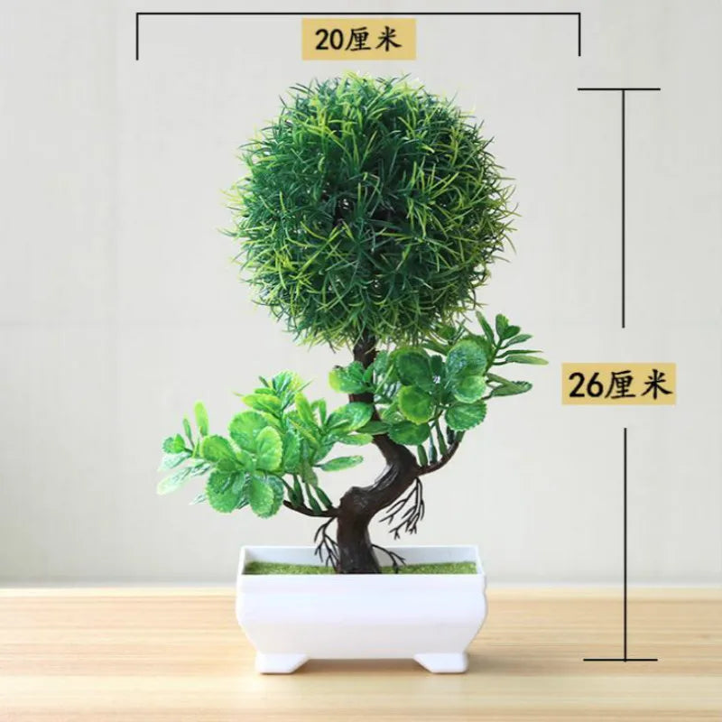 Artificial bonsai tree in a white pot with green foliage, displayed on a wooden surface.
