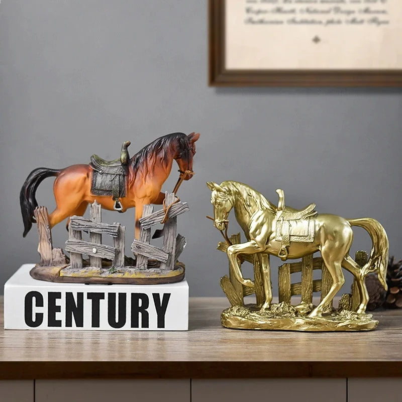 A rustic western horse sculpture with a saddle standing on a wooden fence next to a golden horse sculpture.