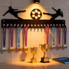 A black metal display rack with 20 hooks for wall mounting, featuring soccer-themed medals and trophies.