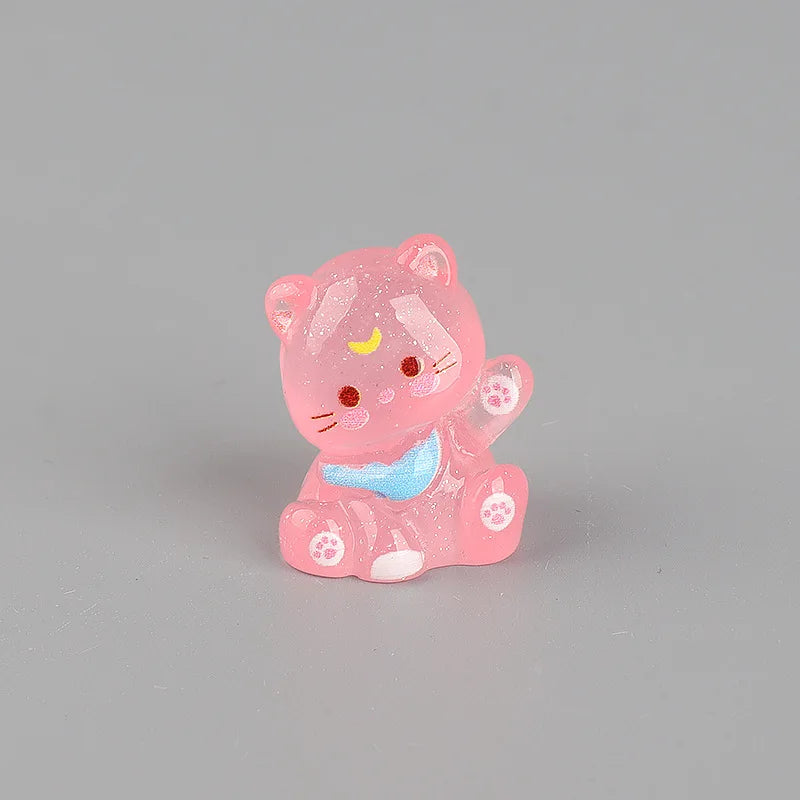 A pink resin keychain shaped like a cute, sleeping cat with a blue collar and yellow accents.