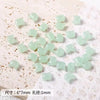 A collection of pale green cat head glass beads for jewelry making, measuring 6x7mm with a 1mm thickness.