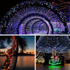 A wide shot of an arched tunnel decorated with numerous multicolored LED string lights illuminating a snowy outdoor scene.