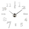 A modern 3D acrylic wall clock showing the time, with DIY sticker numbers for the hours and minutes.