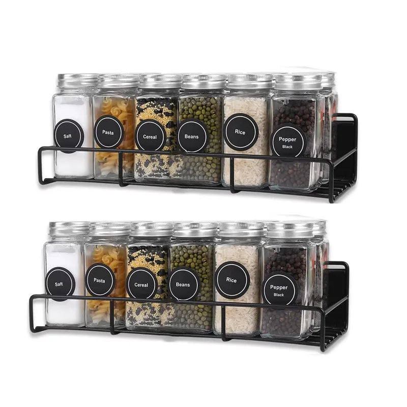 A black magnetic spice rack holding multiple glass jars of various spices and grains for refrigerator storage.