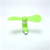 A bright lime green portable USB-C mini fan with soft blades and a silver connector.