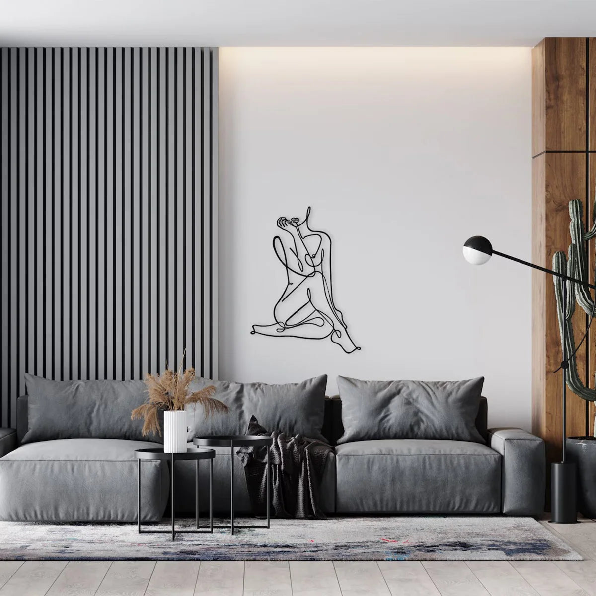 A modern living room featuring a gray sofa and a large black line art drawing of a figure on a white wall.