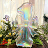 A large, iridescent, transparent number balloon shaped like the number 3, decorated with greenery and flowers.