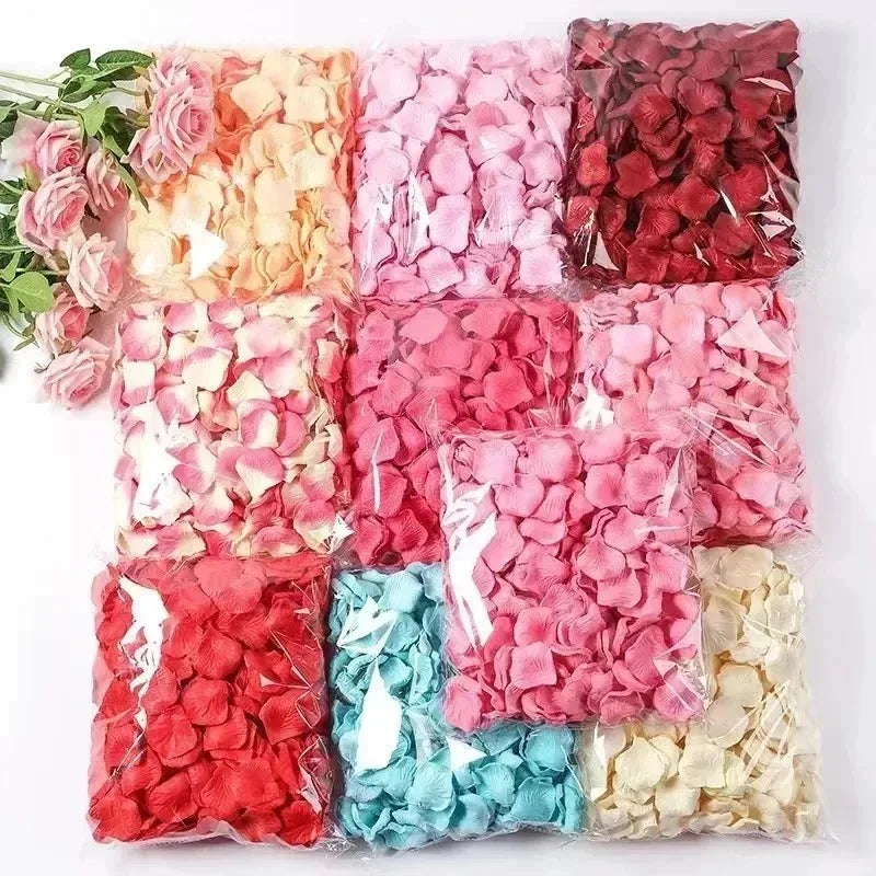 A collection of pink, red, and peach silk rose petals packaged in clear plastic bags for weddings and special events